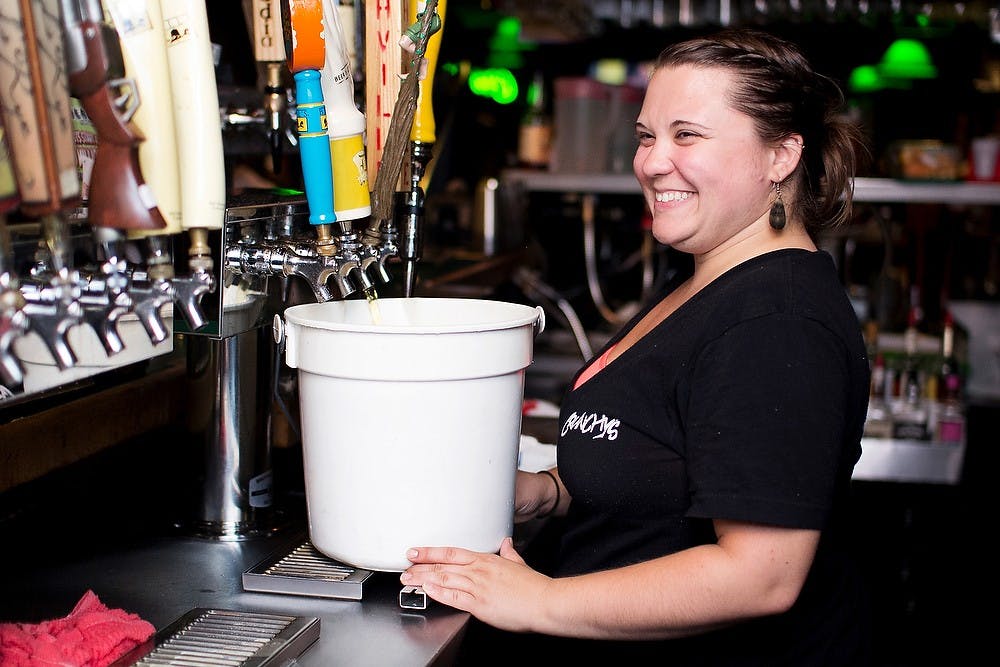 	<p>East Lansing resident and Crunchy&#8217;s bartender Alicia Garnero prepares a bucket of The Locals Light Beer crafted by Short&#8217;s Brew located in Bellaire, Mich., on July 8, 2012. Garnero said the bucket sells for around $29 and is about the same as drinking a 24-pack of beer. State News File Photo</p>