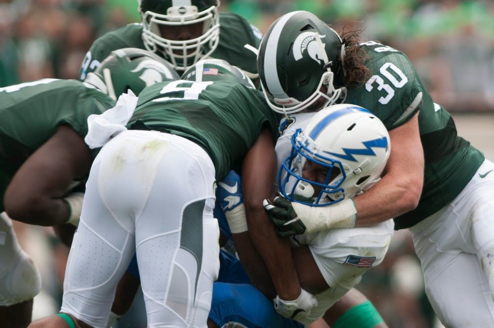 <p>Sophomore safety Montae Nicholson, 9, and junior linebacker Riley Bullough, 30, tackle Air Force's running back Jacobi Owens in the first half during the game against Air Force Sept. 19, 2015 at Spartan Stadium. The Spartans defeated the Falcons 35-21. Kennedy Thatch/The State News</p>