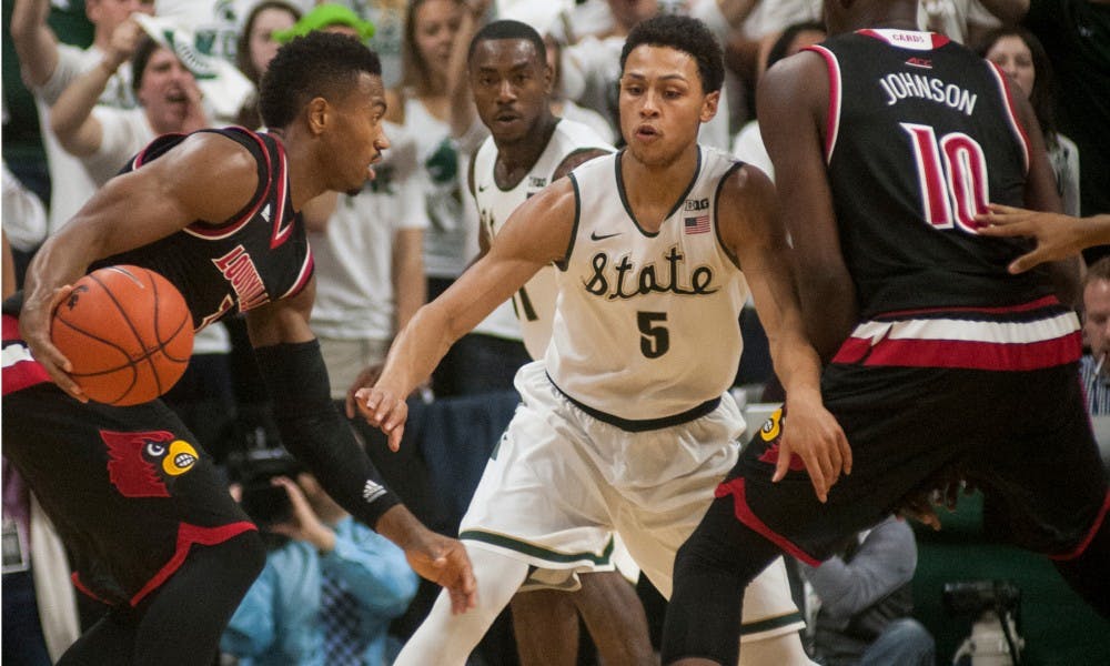 Senior guard Bryn Forbes, 5, defends Louisville guard Trey Lewis, 3, and forward Jaylen Johnson, 10, during the first half of the basketball game against the University of Louisville on Dec. 2, 2015 at the Breslin Center in East Lansing, MI. The Spartans defeated the Cardinals, 71-67.