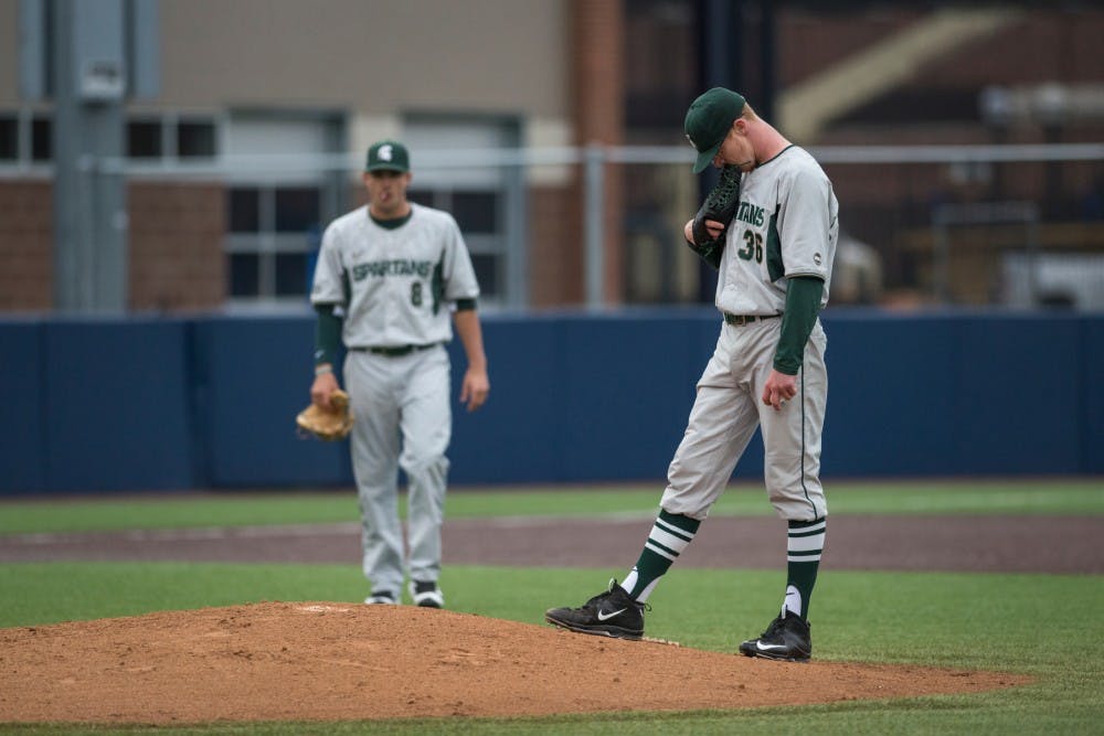 Junior left-handed pitcher Cam Vieaux (36) and senior infielder Justin Hovis (8) gather at the mound during a stoppage of play during the game against Michigan on April 29, 2016 at Ray Fisher Stadium at Wilpon Baseball Complex in Ann Arbor, Mich. The Spartans were defeated by the Wolverines, 4-3.