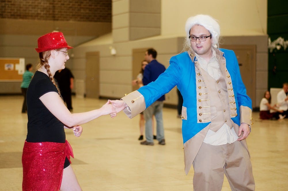 <p>Graduate student Rebecca Ellis, left, and history senior Nathan Story, right, swing dances Nov. 2, 2014, at Dem Hall. The State Swing Society meets every Sunday with lessons from 7:30-9 p.m. and open dance from 9-10 p.m. Aerika Williams/The State News </p>