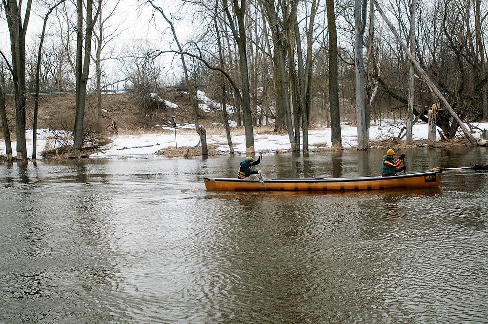 <p>Michigan State alumni Tom Baweja and Tim "Boot" Muhich canoe March 20, 2014, down the Red Cedar River near Kruger Landing. The two plan to canoe the entire Mississippi River in less than 18 days this coming May. Allison Brooks/The State News</p>
