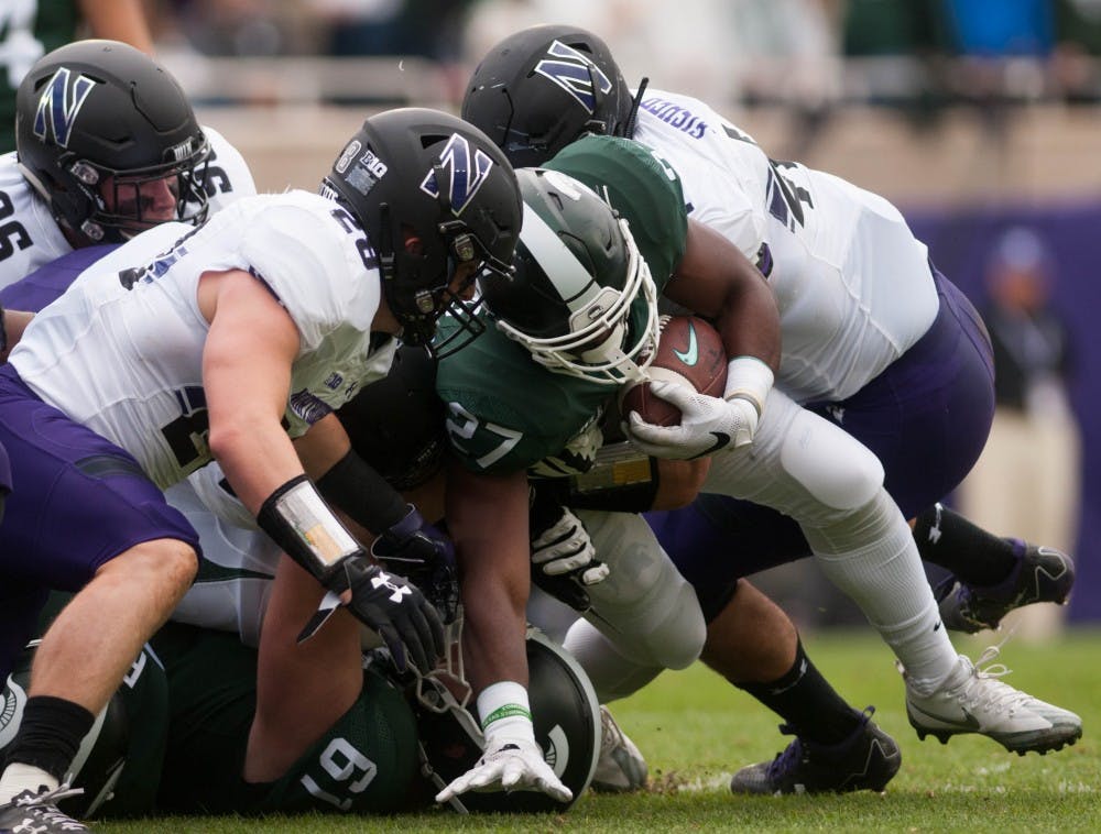 Northwestern players tackle red-shirt freshman runningback Weston Bridges (27) during the game at Spartan Stadium on Oct. 6, 2018. The Spartans trail the Wildcats 14-6 at halftime.