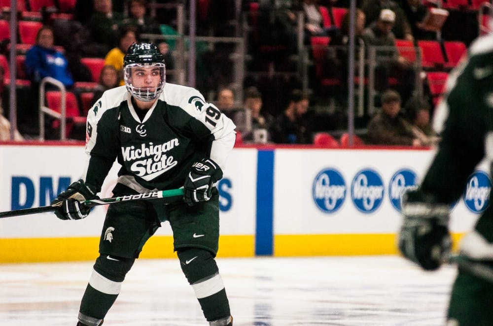 Freshman forward David Keefer (19) watches the puck during the game against Michigan Tech on Jan. 1, 2018, at Little Caesars Arena. The Spartans were defeated by the Huskies 5-2. 