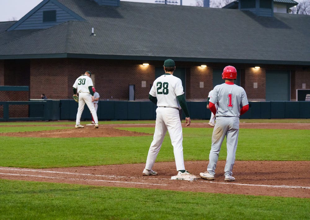 <p>Michigan State sophomore Brock Vradenburg carefully watches sophomore Kyle Dunning and Youngtown State senior Lucas Nasonti as he leads up to steal, on March 30, 2022. Spartans are victorious 12-5 against Youngtown State.</p>