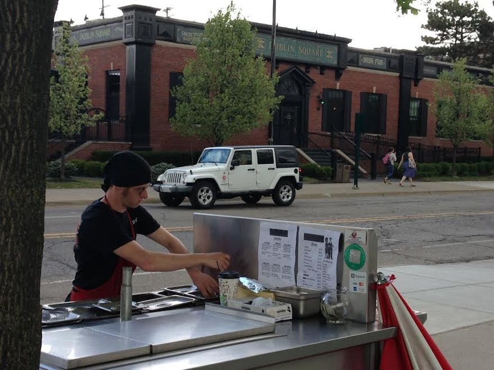 <p>Hank's Hotdogs owner Benjamin Scheffler works his food cart, located on the corner of Abbot Road and Albert Avenue. Hank's Hotdogs will be operating until the Concessionaire's Pilot Program ends May 7. Scheffler will then have the option to purchase a one-year license to continue operating in the space.</p>