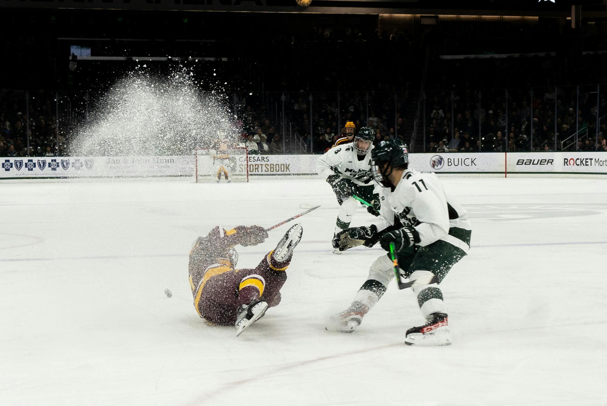 University of Minnesota player falls during a game at Munn Ice Arena on Dec. 2, 2022. The Spartans lost to the Gophers with score 5-0. 