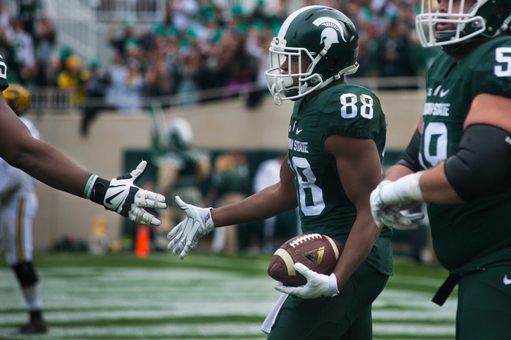 Senior wide receiver Monty Madaris (88) high fives a teammate after scoring a touchdown during the game against Michigan on Oct. 29, 2016 at Spartan Stadium. The Spartans were defeated by the Wolverines, 32-23.