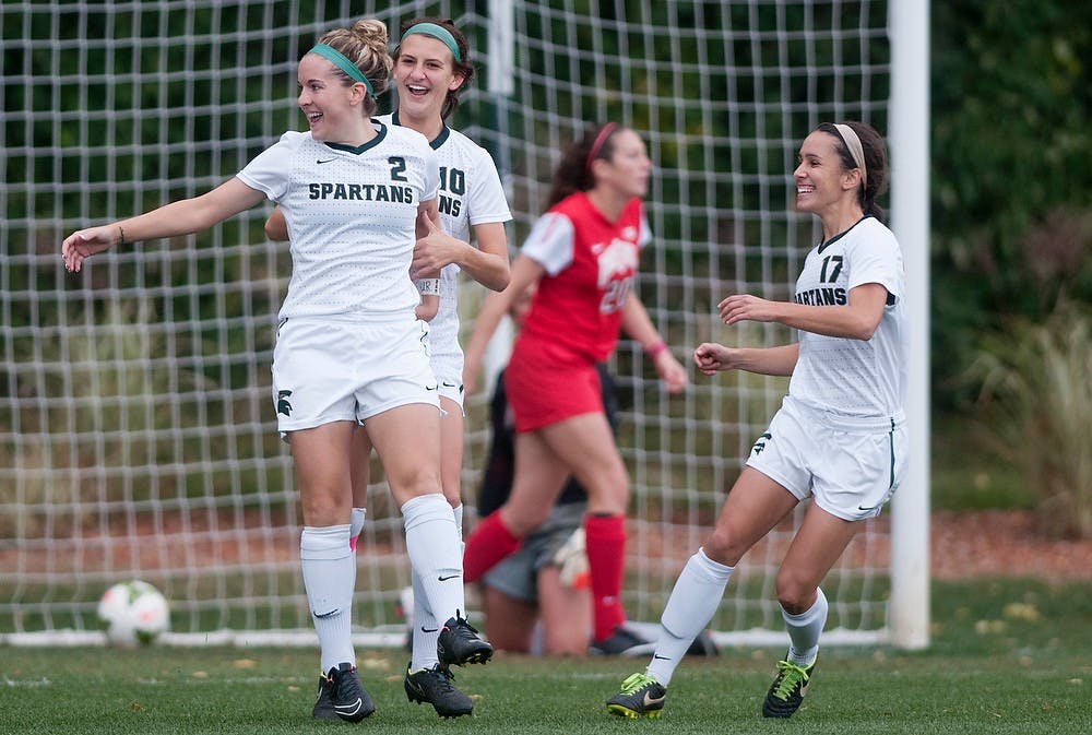 <p>Senior midfielder Megan Marsack, 10, and junior midfielder Sarah Kovan, 17, celebrate a goal made by junior forward Allyson Krause, 2, during the game against Ohio State on Oct. 16, 2014, at the DeMartin Soccer Stadium at Old College Field. The Spartans defeated the Buckeyes, 2-1. Jessalyn Tamez/The State News </p>