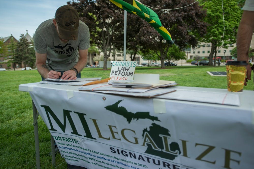 Albion, Mich. resident Stan McKim fills out a petition form during the MILegalize Capitol Rally on May 20, 2016 at the Capitol in Lansing. The MILegalize Capitol Rally was held to gather signatures in the support of the legalization of cannabis and express the community's frustration with legislators.