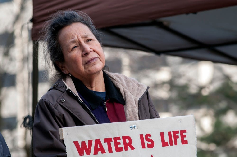 A woman holds a sign during a rally on Dec. 5, 2016 at the Capitol in Lansing. The rally was held to show solidarity with the Standing Rock Sioux tribe, sharing their opposition to the Dakota Access Pipeline. 