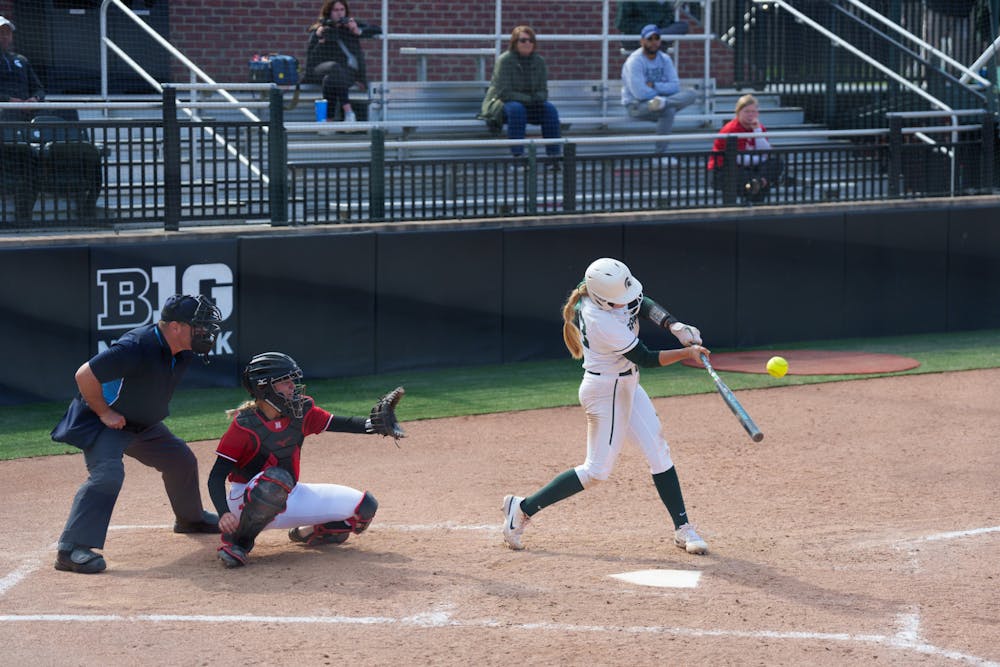 <p>Michigan State senior Jessica Mabrey hits a fly ball to center field in the fourth inning. Spartans lost 5-4 against Nebraska, on April 10, 2022.</p>