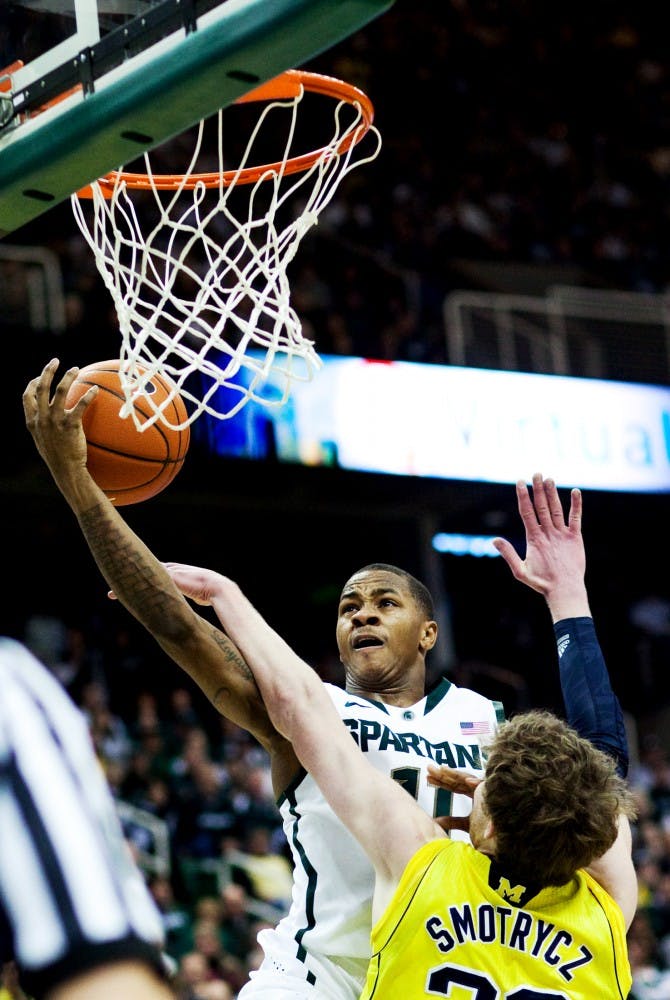 Sophomore guard Keith Appling is fouled by Michigan forward Evan Smotrycz Sunday afternoon at Breslin Center. Appling added 10 points to the Spartans total in the 64-54 victory over Michigan. Matt Hallowell/The State News