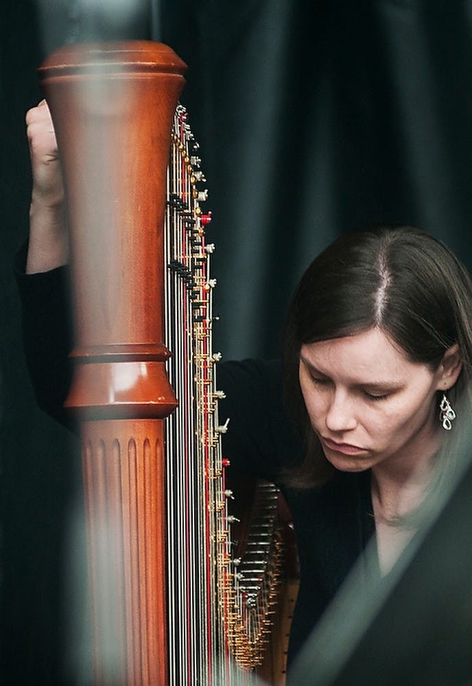 	<p>Lansing Symphony Orchestra harpist Brittany DeYoung tunes her instrument before the Summer Pops Concert, June 5, 2013, at Adado Riverfront Park in Lansing. The Lansing Symphony Orchestra was performing songs from the &#8217;80s. Danyelle Morrow/The State News</p>