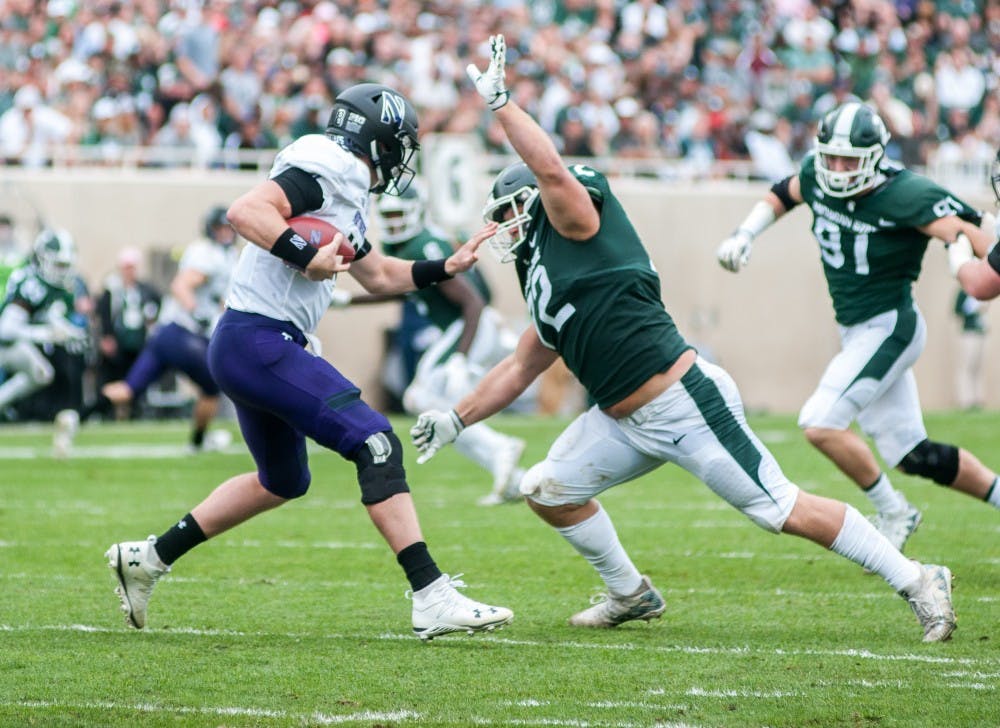 Junior defensive tackle Mike Panasiuk (72) breaks through the backfield to sack Northwestern quarterback Clayton Thorson (18) during the game against Northwestern on Oct. 6, 2018 at Spartan Stadium. The Spartans trail the Wildcats 14-6 at halftime.