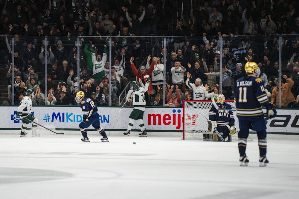 <p>Tommi Männistö, a junior forward (10), and Tiernan Shoudy, a senior forward (13) for the Michigan State University hockey team, celebrate with fans after scoring against Luke Pearson (30), a graduate student for the University of Notre Dame hockey team, at Munn Ice Arena in East Lansing, Michigan, on Friday, Feb. 20, 2026.</p>