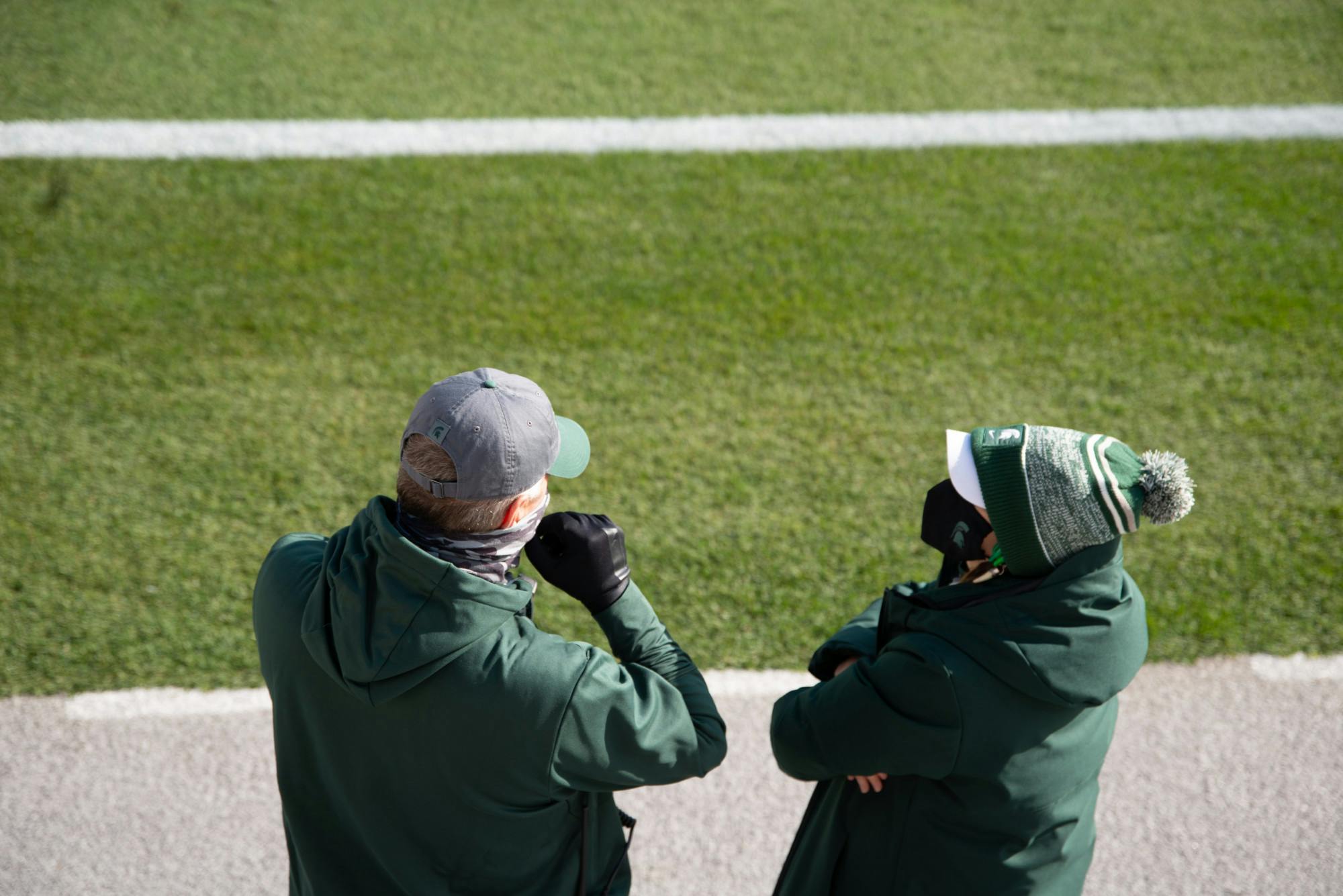 <p>Members of Spartan athletics watch the team warm up before a football game against Indiana University at Spartan Stadium on Nov. 14, 2020.</p>