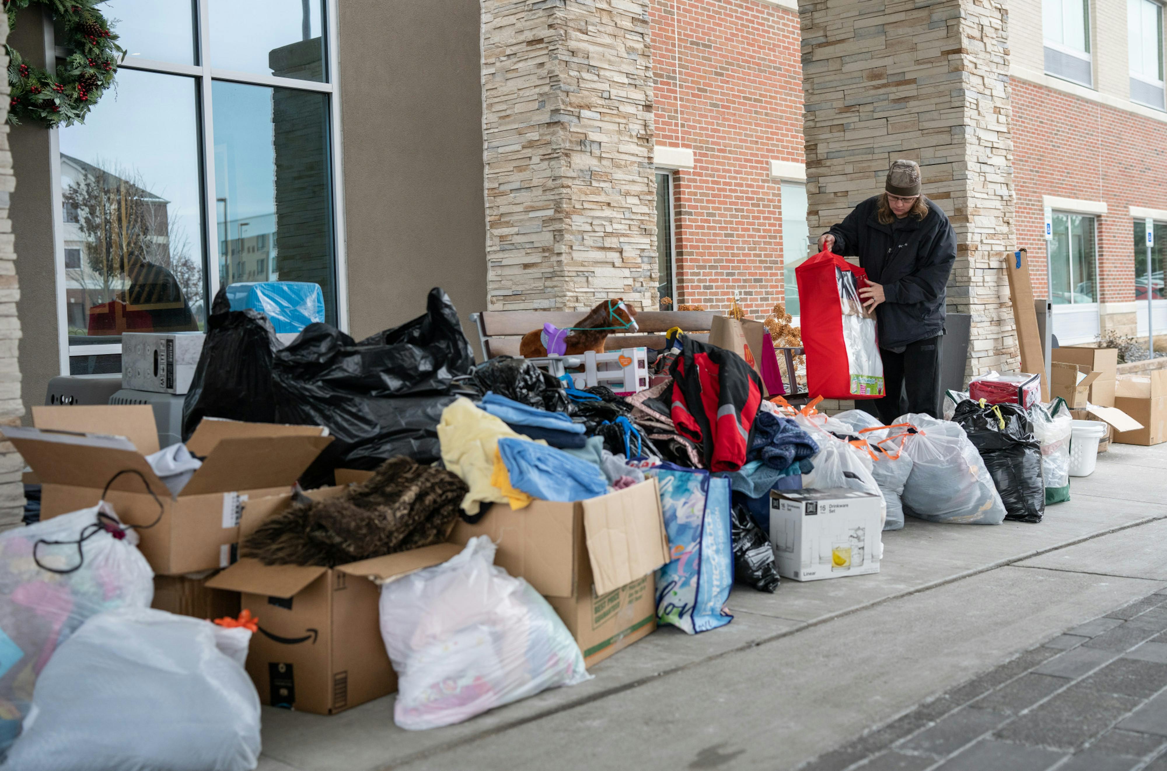 Community members drop off donations to the Holiday Inn Express & Suites where displaced families of the Knob Hill apartment fires are staying on Dec. 22, 2022. Donations included clothes, shoes, winter jackets and boots, food, toiletries, chargers and Christmas presents. 