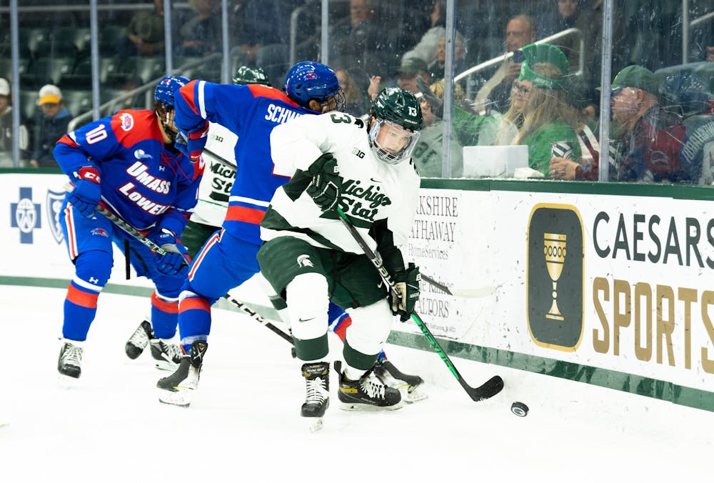 <p>Freshman forward Tiernan Shoudy (13) skates passed UMass Lowell players during a game at Munn Ice Arena on Oct. 13, 2022. The Spartans defeated the River Hawks with a score of 4-3.&nbsp;</p>
