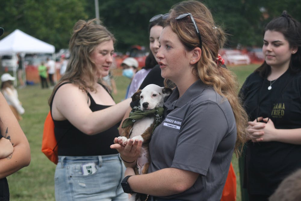 Premed junior Sarah Farrar carries a puppy as she represents the Stronger Warrior Foundation; a veteran run, nonprofit organization. Photographed at Sparticipation on Aug. 31, 2021.