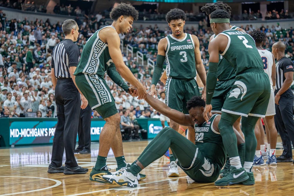 Teammates help senior center Mady Sissoko (22) off the floor after falling during a game against Southern Indiana at the Breslin Center on Nov. 9, 2023. The Spartans defeated the Screaming Eagles 74-51. 