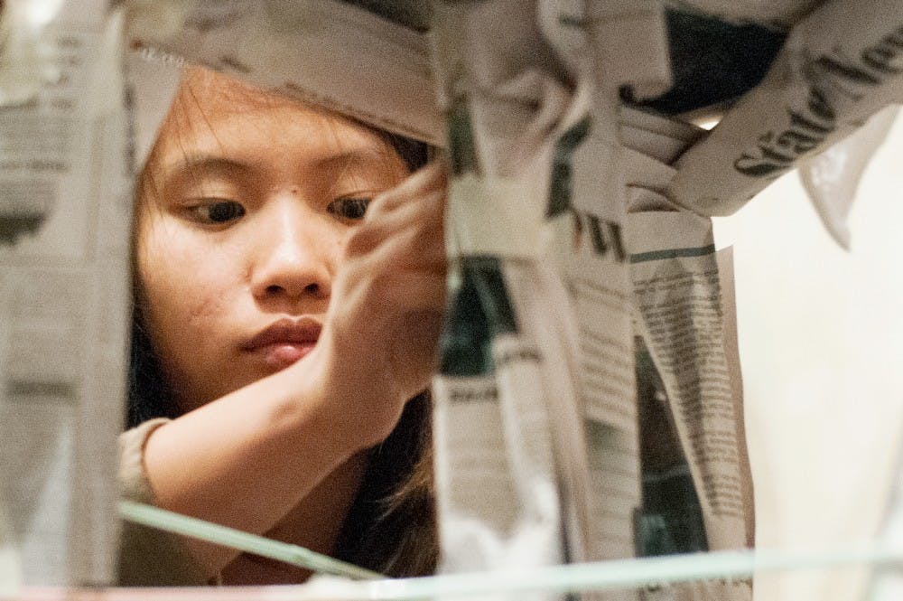 Lansing resident Huong Nguyen, 17, tapes together newspapers during a team building exercise at the Girls 2 Women conference in the Union ballroom on June 15, 2012. The conference included guest speakers and workshops about transitioning into womenhood. Julia Nagy/The State News