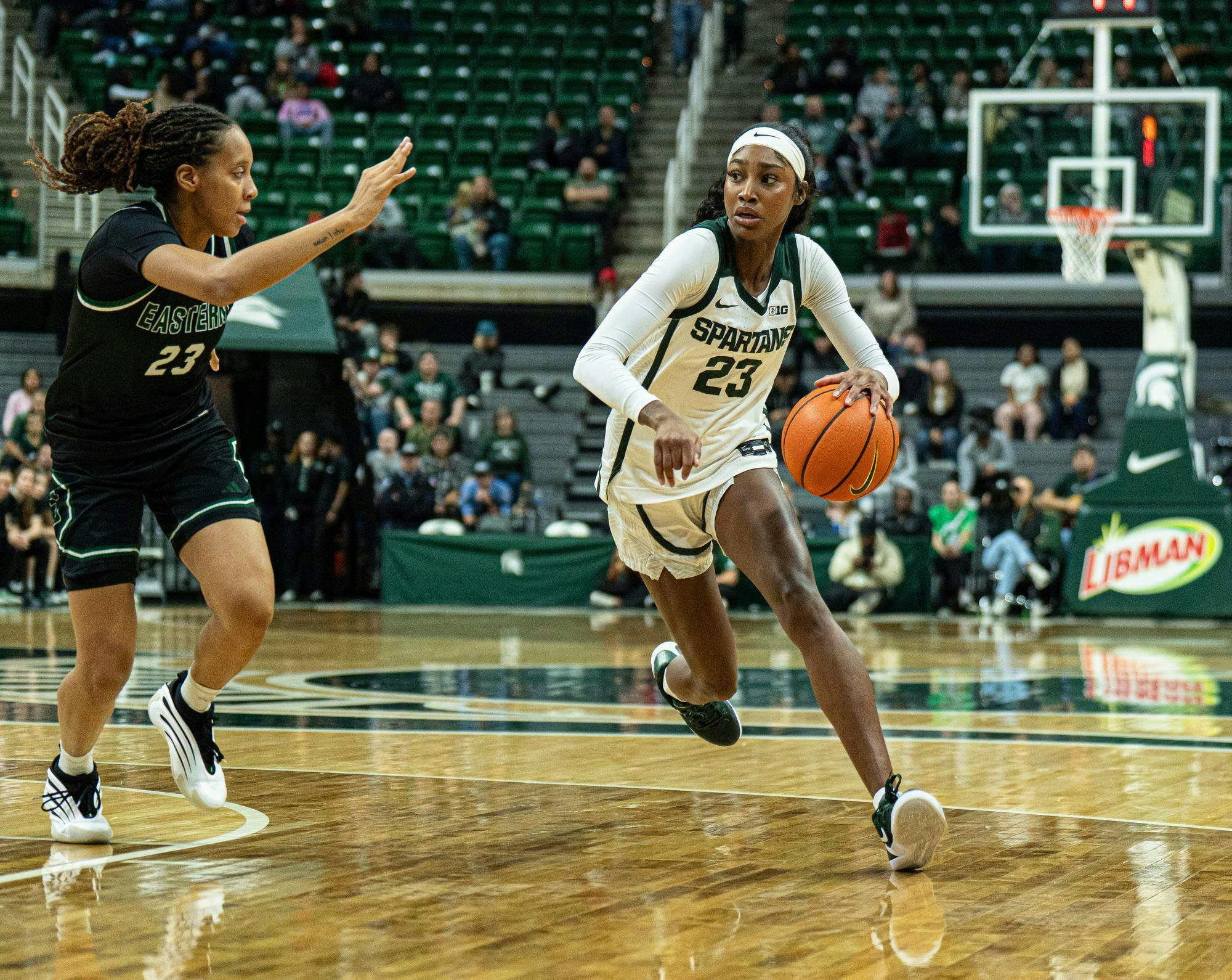 MSU senior guard, Jalyn Brown (23) running by Eastern Michigan player Peyton Hill (23) during the MSU versus Eastern Michigan Women's Basketball game at Michigan State University's Breslin Center on Sunday, Nov. 9, 2025
