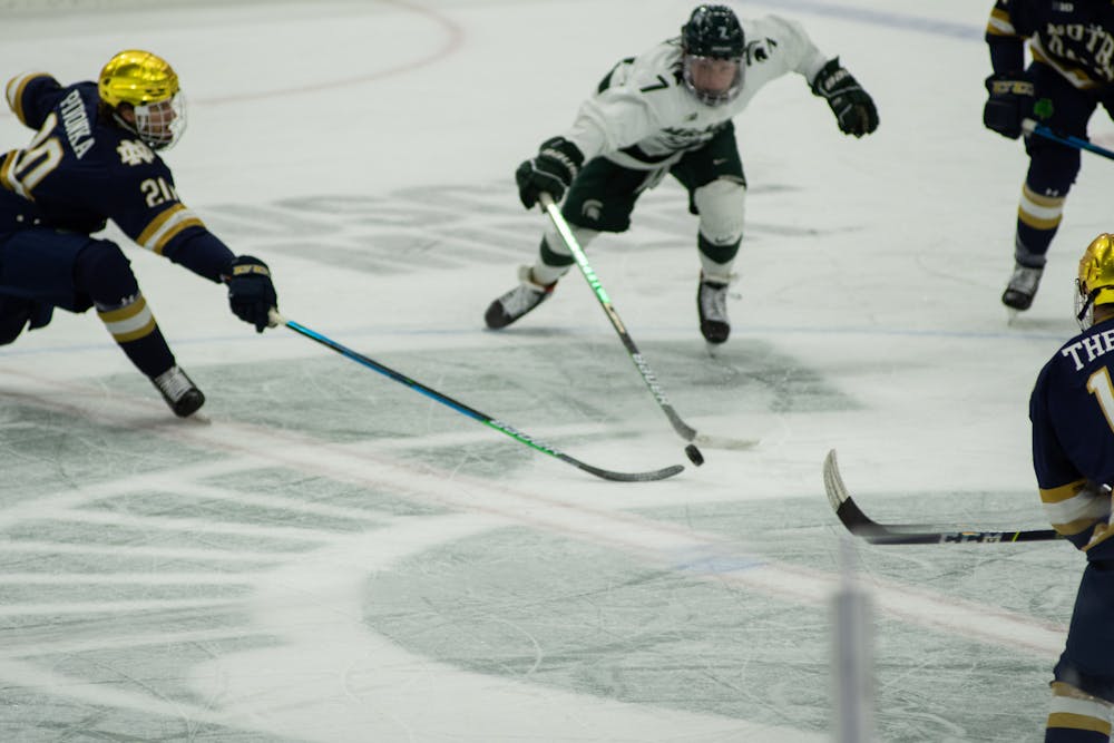 <p>Michigan State&#x27;s Charlie Combs (7) and Notre Dame&#x27;s Jake Pivonka (20) reach for posession of the puck in Notre Dame&#x27;s victory over MSU on Feb. 26, 2021. </p>