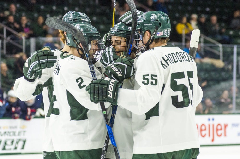 The Spartans celebrate with freshman defenseman Damian Chrcek (7), center, after scoring the second goal of the game during the first period in the exhibition game against U.S. National Team Development Program U-18 Program on Dec. 4, 2016 at Munn Ice Arena. The Spartans led the first period, 2-1.