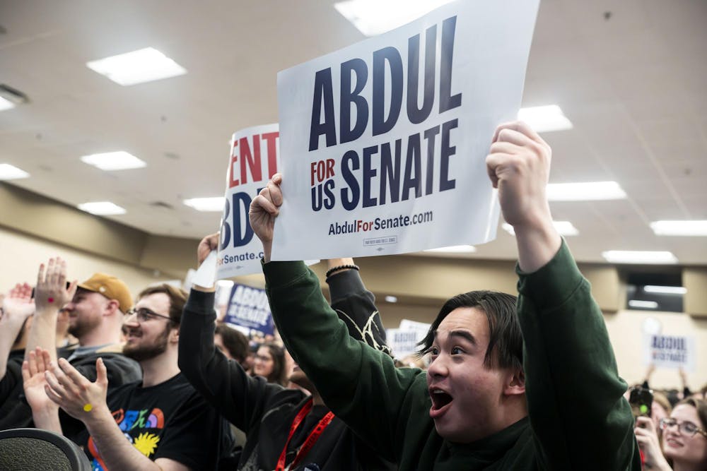 Recent MSU graduate Benjamin Zhang holds up an Abdul for Senate sign at the Abdul El-Sayed rally in Armstrong hall in East Lansing, Mich., on April 7, 2026. 