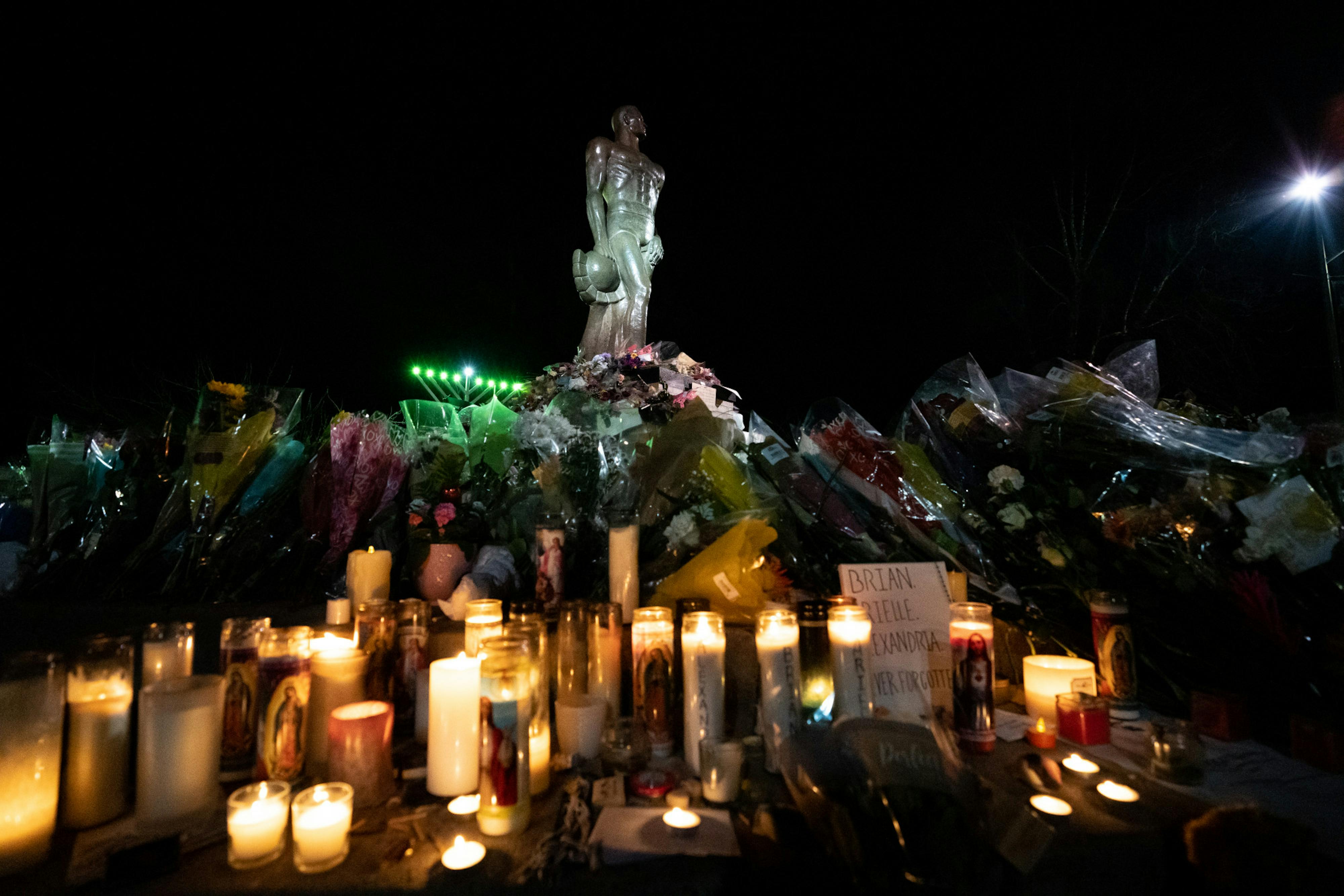 Candles, flowers and letters fill the base of the Spartan Statue on Feb. 19, 2023, acting as a memorial for Brian Fraser, Alexandria Verner and Arielle Anderson who lost their lives in a mass shooting at Michigan State University on Feb. 13.