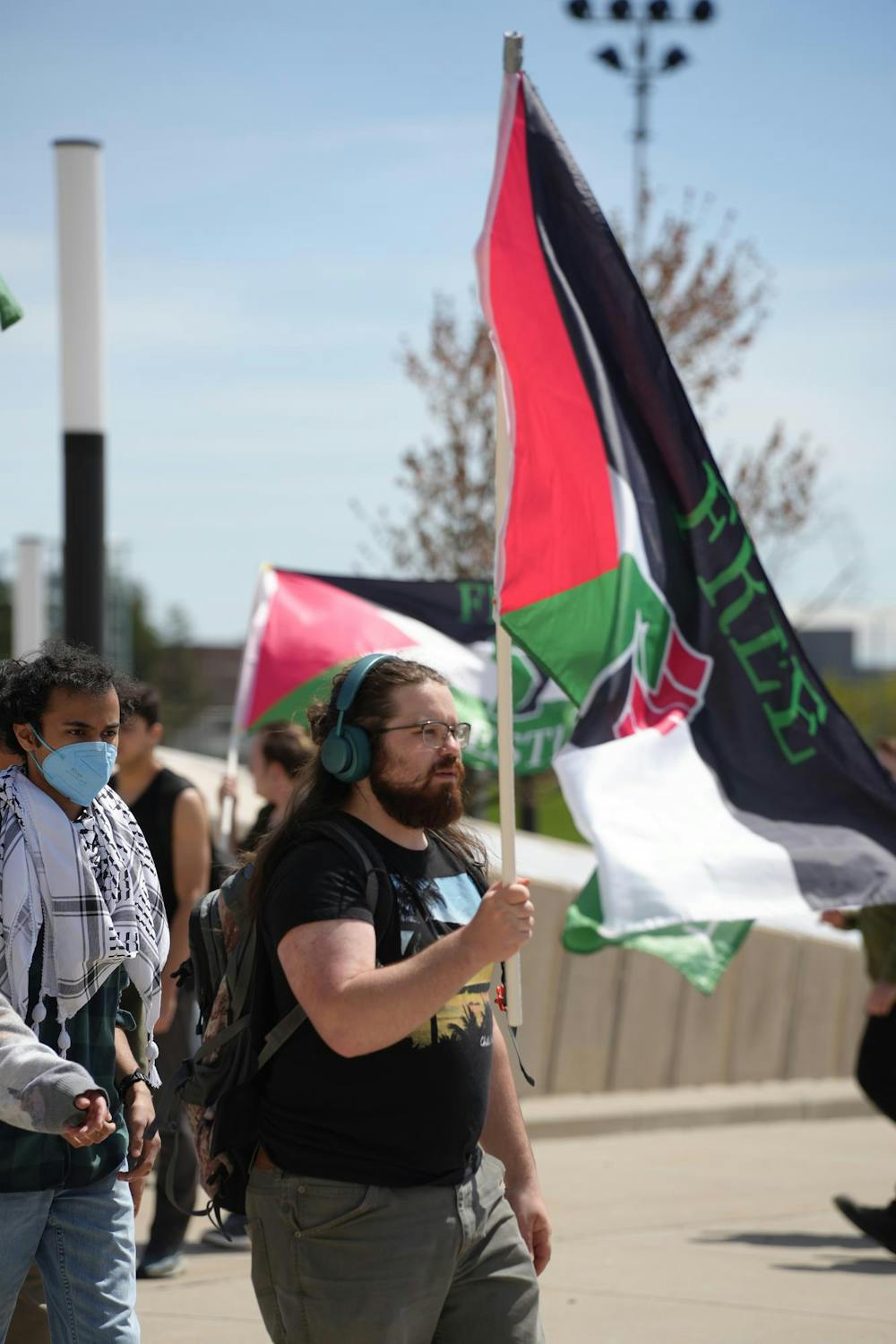 A protestor holds the Palestinian flag during a protest outside of the Breslin Center on April 26, 2024. Protestors demanded that the university divest from Israel. 