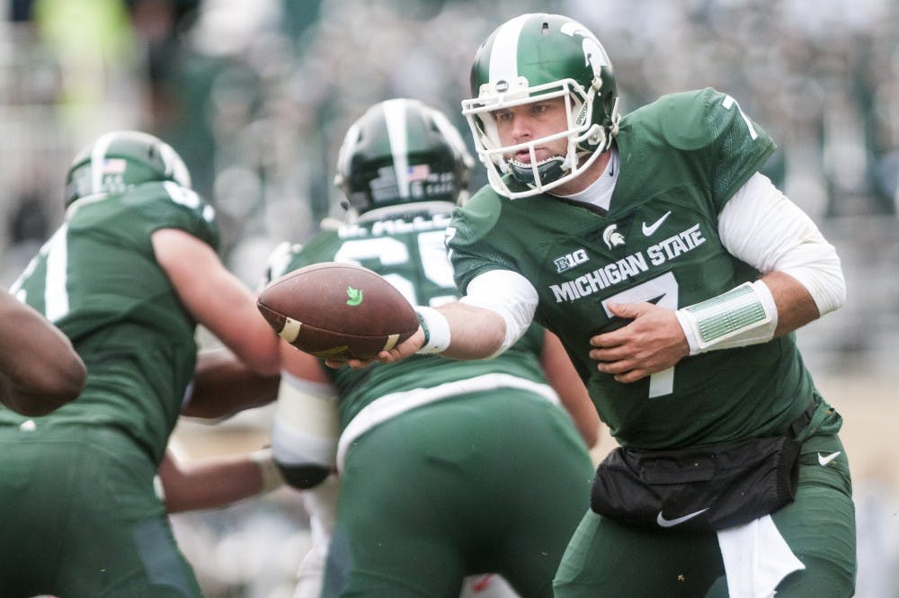 Senior quarterback Tyler O'Connor (7) holds out the football for a handoff during the first half of the game against Ohio State on Nov. 19, 2016 at Spartan Stadium. The Spartans were defeated by the Buckeyes, 17-16.