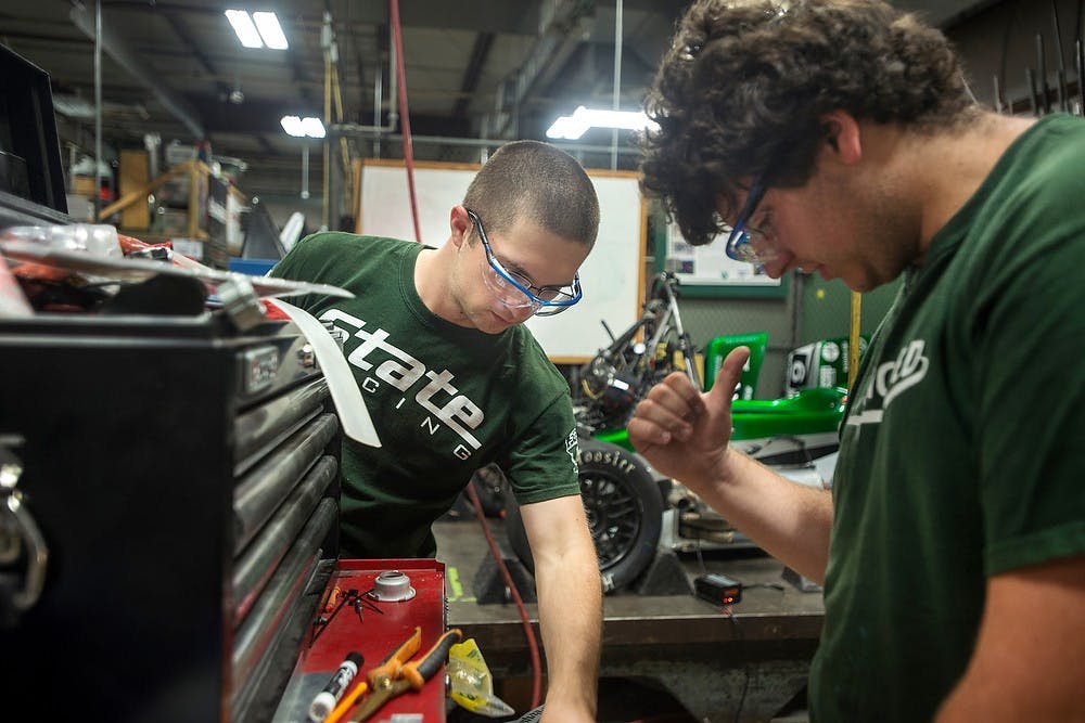 	<p>Mechanical engineering sophomores Chris Churay, left, and Jake Overla try to find tools to fix the engine, Aug. 4, 2013, at the <span class="caps">MSU</span> Research Facility, 2857 Jolly Road in Okemos. <span class="caps">MSU</span> Formula Racing Team uses the facility to design and build race cars. Justin Wan/The State News</p>
