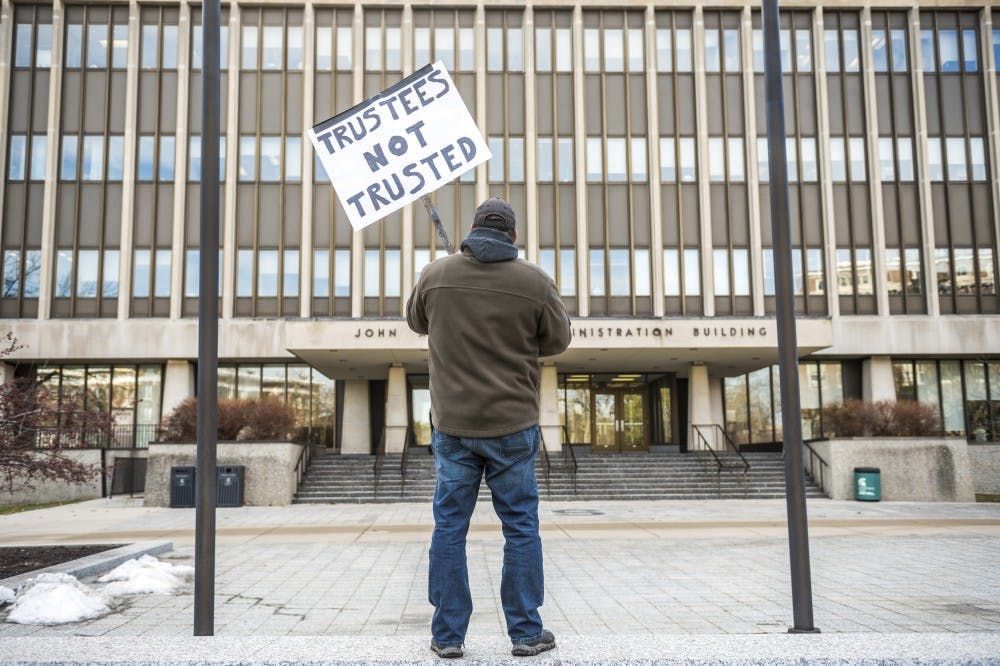 Bernie Trautmann of West Bloomfield protests after the MSU Board of Trustees public meeting discussing MSU's presidential transition on Jan. 26, 2018 outside of the Hannah Administration Building. Trautmann said he graduated from MSU in 1989 and he has a son who is a current MSU student. His high school senior daughter is planning to attend MSU in the fall. "I'm here to protect my children from the incompetence of the trustees," Trautmann said. (Nic Antaya | The State News)
