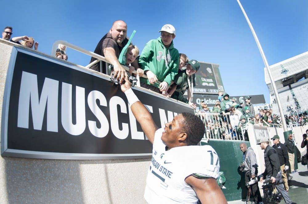 Junior linebacker Tyriq Thompson (17) hands his gloves to a member of the crowd after the Green and White Spring Game on April 1, 2017 at Spartan Stadium. The White team defeated the Green team, 33-23.