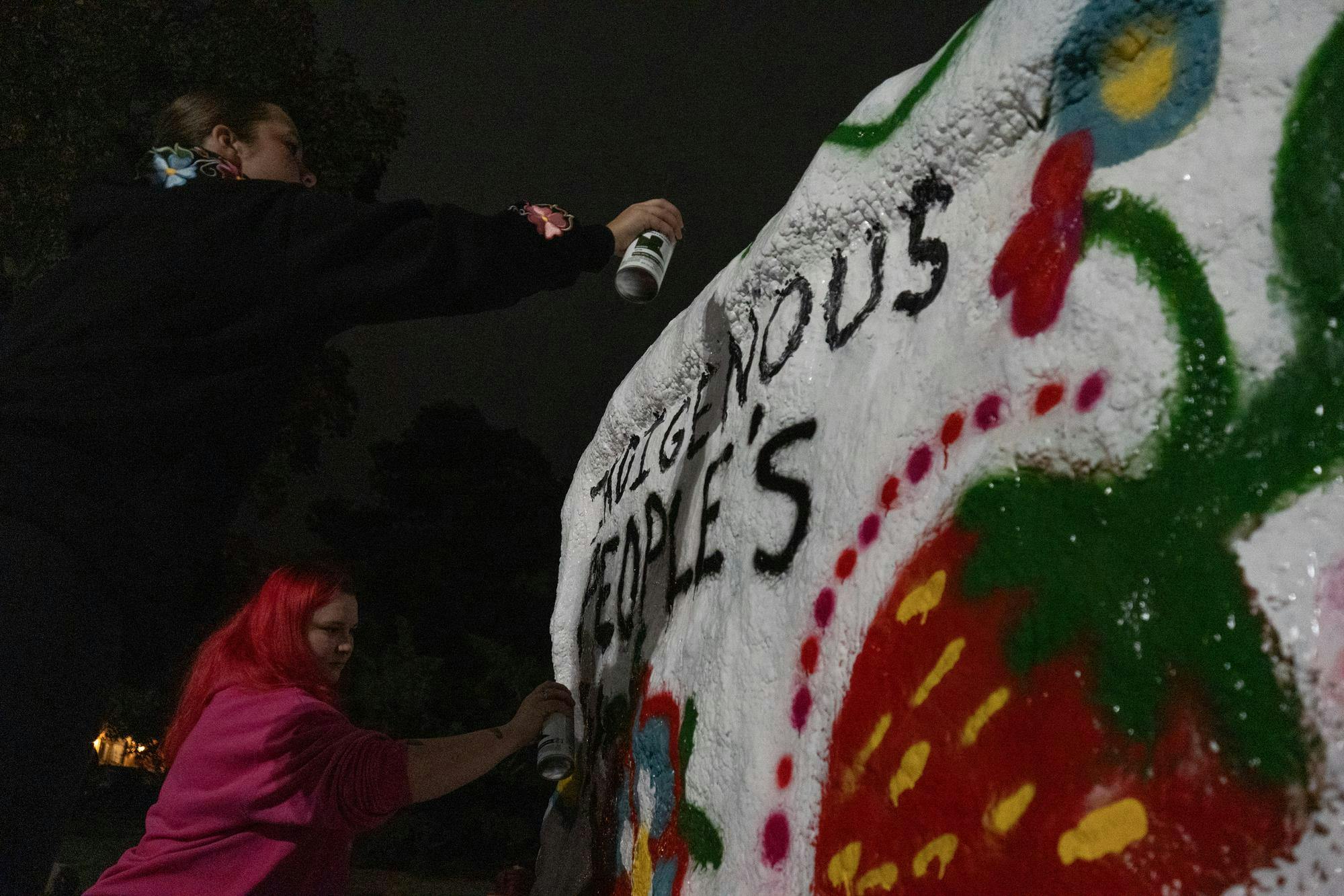 <p>Michigan State students and members of the Michigan State North American Indigenous Student Organization, Brielle Tate and Sarah Lettau (from left), paint The Rock on Farm Lane for Indigenous Peoples' Day in East Lansing, Mich., on Sunday, Oct. 11, 2026.</p>