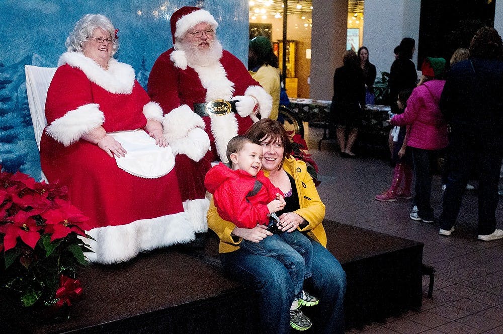 <p>Lansing resident Carrie Feeheley, also a staff member at the MSU College of Law, poses with her son Sean Feeheley, 3, in front of Santa and Mrs. Claus at Winter Glow on Saturday, Dec. 1, 2012, in downtown East Lansing. Winter Glow included a reindeer petting zoo, ice carving and a marshmallow roast, among many other activities. Katie Stiefel/ State News</p>