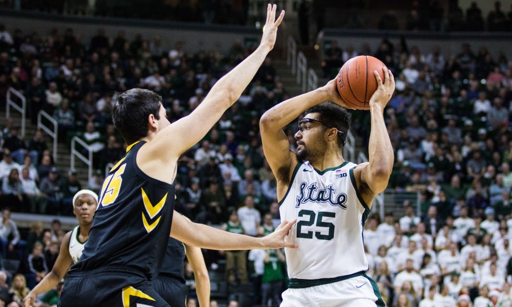 Senior forward Kenny Goins (25) looks for an open pass during the game against Iowa University at Breslin Center on Dec. 3, 2018. The Spartans defeated the Hawkeyes, 90-68.