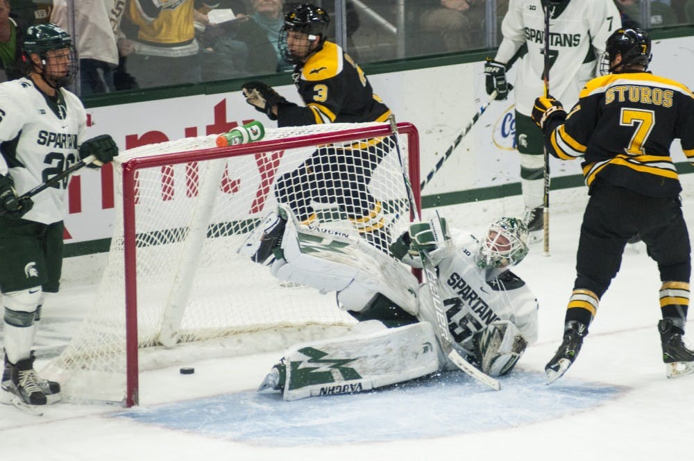 Junior goaltender Ed Minney (45) leans over as the puck enters the goal in the game against Michigan Tech on Nov. 4, 2016 at Munn Ice Arena. The Spartans defeated the Huskies in overtime, 3-2.