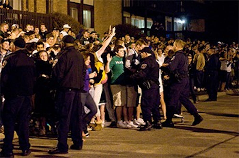 <p>A crowd of people gets pushed into the street near Cedar Village apartments as police officers try to keep them on the sidewalk at about 9 p.m. on April 3, 2010. Many people were chanting to rush the streets, but police had the street cleared by 11 p.m. State News File Photo</p>