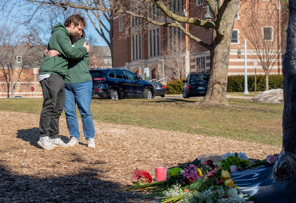 <p>Michigan State University business freshman Matthew Bowersock hugs his mother, Mary, as they pay their respects to the victims of the mass shooting at Michigan State University on Feb. 14, 2023, at The Rock on Farm Lane.</p>