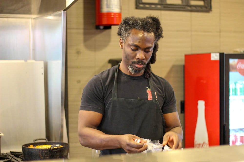 <p>Handie owner Taiwo Adeleye&nbsp;is preparing to cook traditional Nigerian food for customers before their opening later this month. The grand opening of Handie’s new location is on Oct. 24th, 2024.</p>