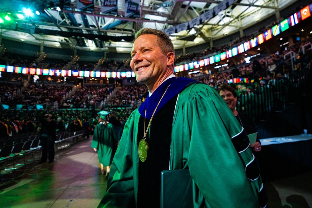 MSU president Kevin Guskiewicz steps out onto the floor during the fall 2024 commencement ceremony at the Breslin Center on Dec. 14, 2024.