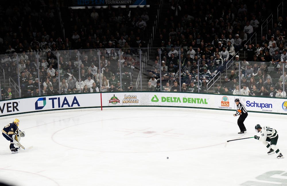 <p>Michigan State junior right wing Joey Larson (18) and Notre Dame junior goaltender Owen Say (30) track a loose puck at Munn Ice Arena on March 15, 2025. The Spartans took a 1-0 victory over the Fighting Irish, advancing to the Big Ten Championship.</p>