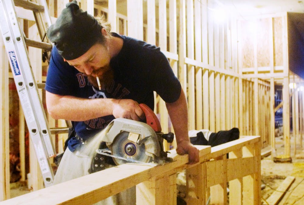 Chris Parks of DeLong Builders Inc. carefully cuts wood to further construct Moe's Southwest Grill, 551 E. Grand River Ave. The restaurant is expected to be opened later this spring. Anthony Thibodeau/The State News