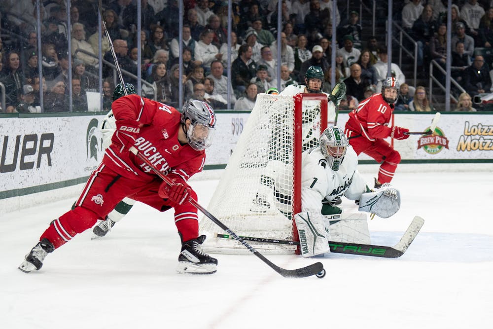 Graduate student forward Dalton Messina (14) taking a shot against freshman goalie Trey Augustine (1) during a game between Ohio State University and Michigan State University at Munn Ice Arena on Feb. 24, 2024.