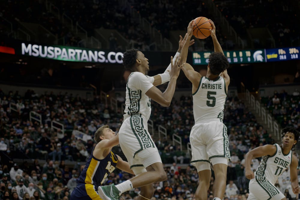 <p>Senior forward Marcus Bingham and freshman guard Max Christie take charge for the ball. </p>
