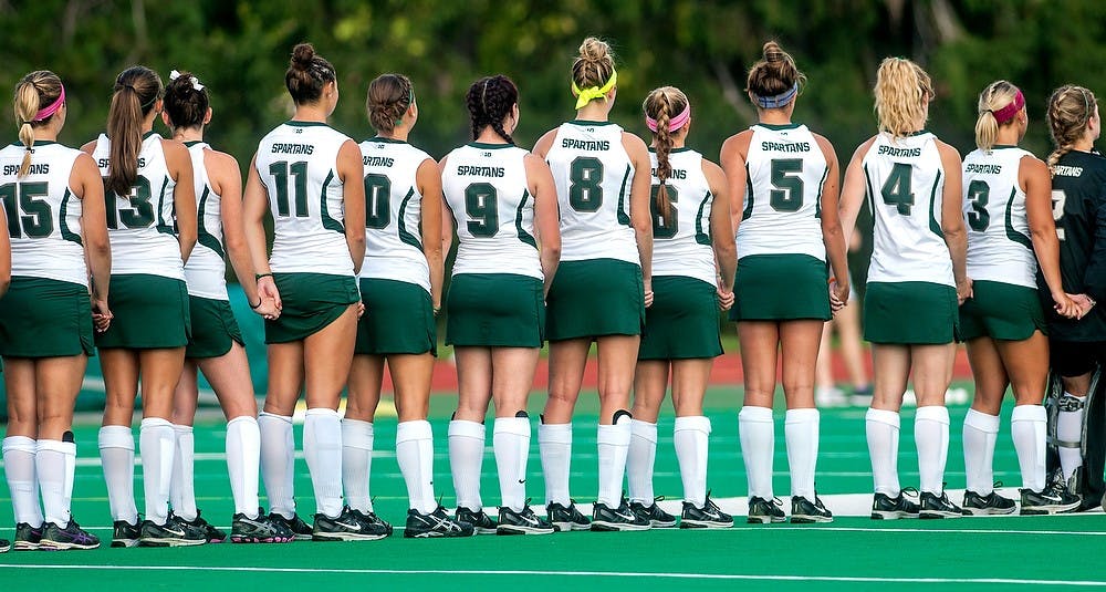 <p>The team holds hands as the national anthem is played before a game against the University of Maine on Aug. 31, 2014, at Ralph Young Field. The Spartans defeated the Black Bears, 5-4 in overtime. Jessalyn Tamez/The State News </p>