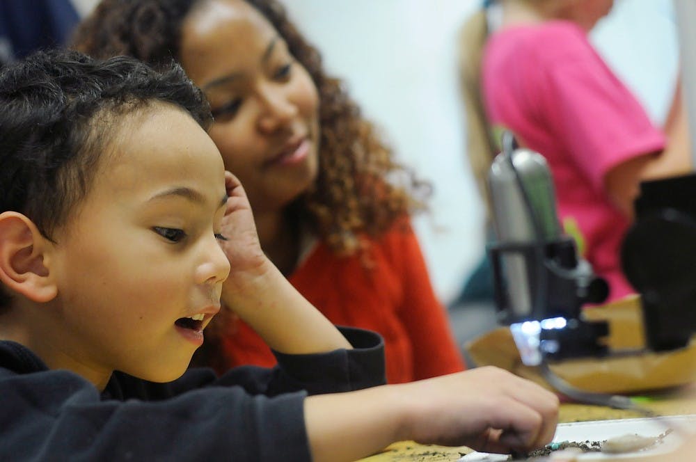 	<p>Lansing residents Jackson Canfora, 4, and Chong-Anna Canfora look at artifacts through a lens during the &#8216;Dig the Past&#8217; event on Nov. 16, 2013, at the <span class="caps">MSU</span> Museum. The event was geared towards children and families to spark interest in archeology. Brian Palmer/The State News</p>